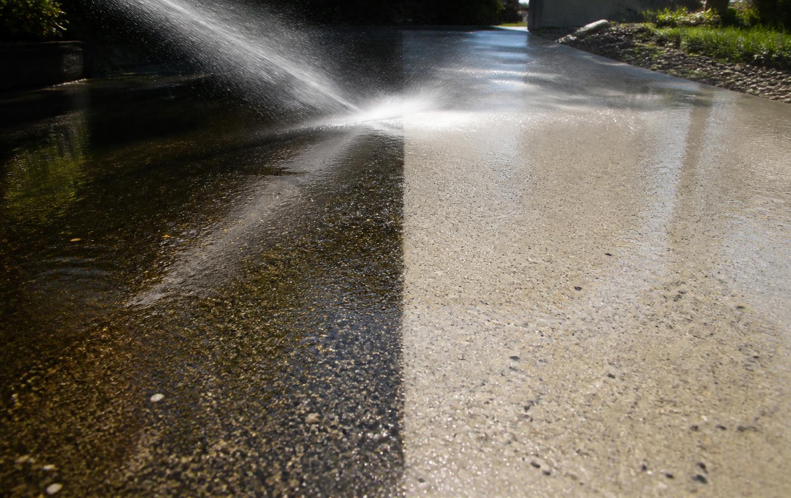 Driveway half black with grime, half pressure-cleaned bright concrete
