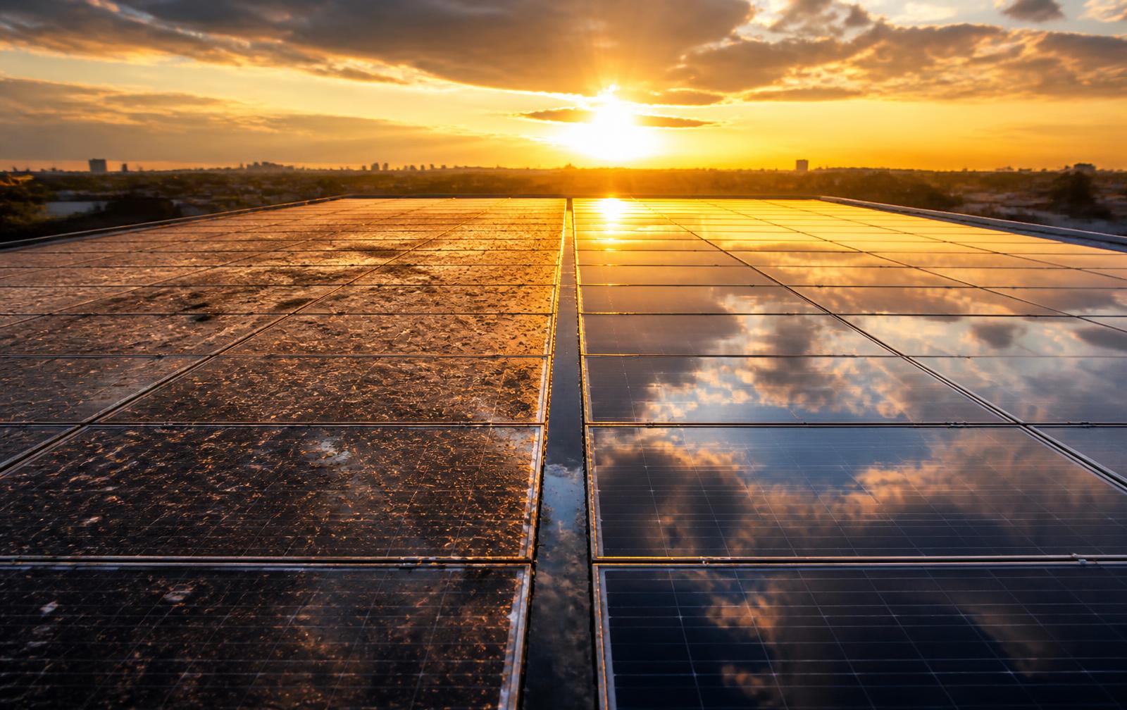 Solar array half dusty and dull, half mirror-clean at sunrise
