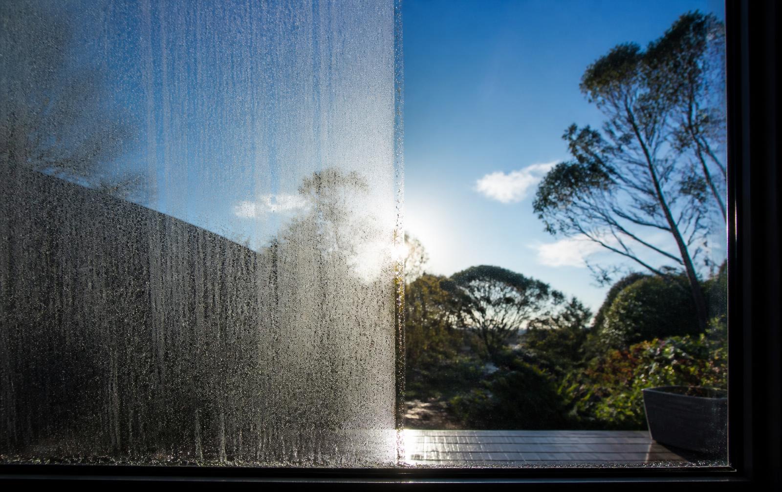 Window pane half hazed with mineral spotting, half crystal clear